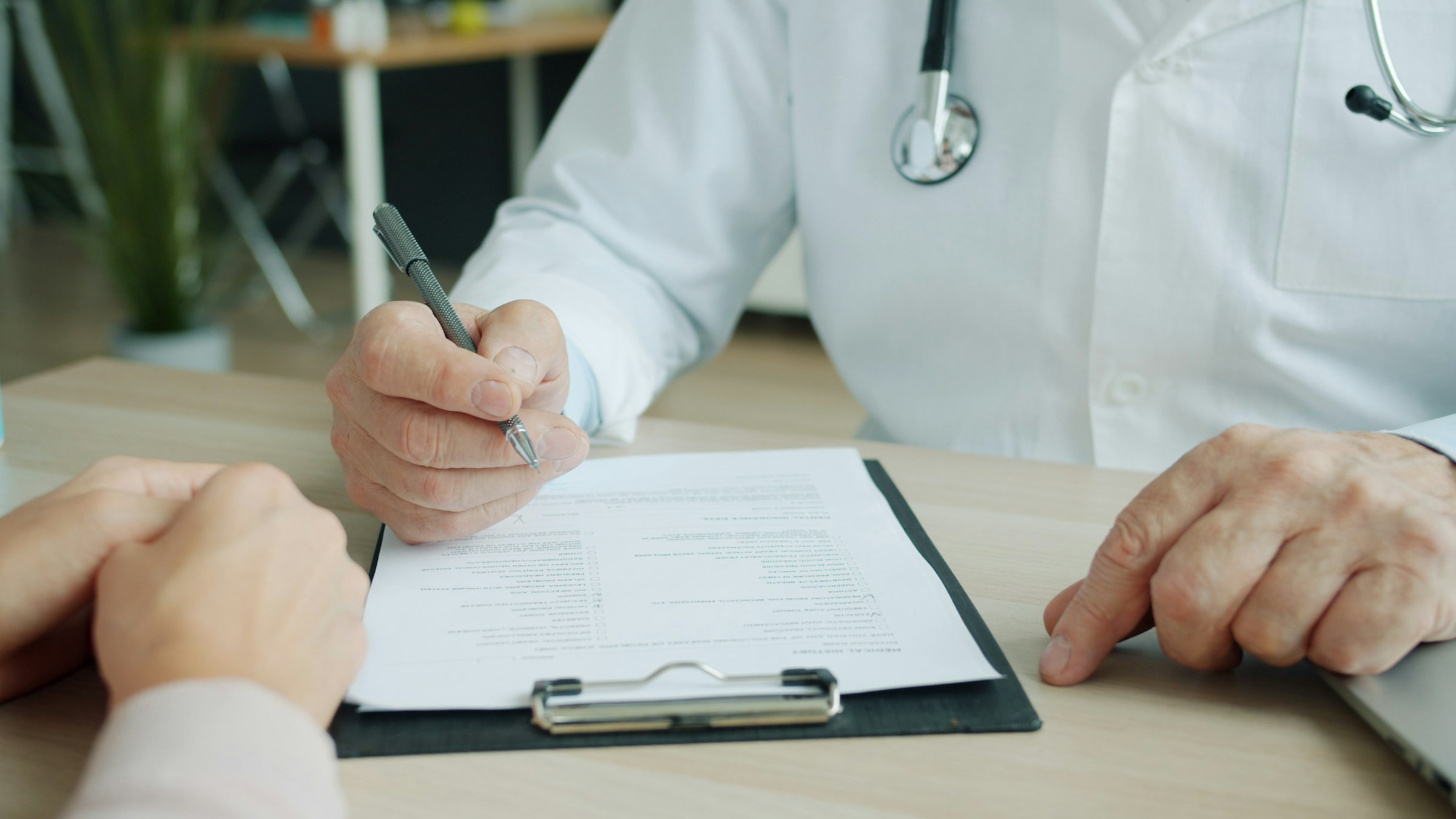 Doctor writing on a patient chart